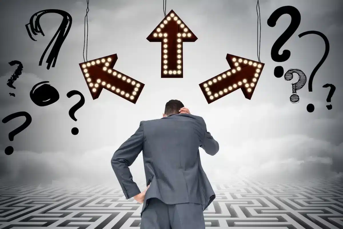 Man facing multiple signs and question marks above a maze, indicating confusion and decision-making challenges.