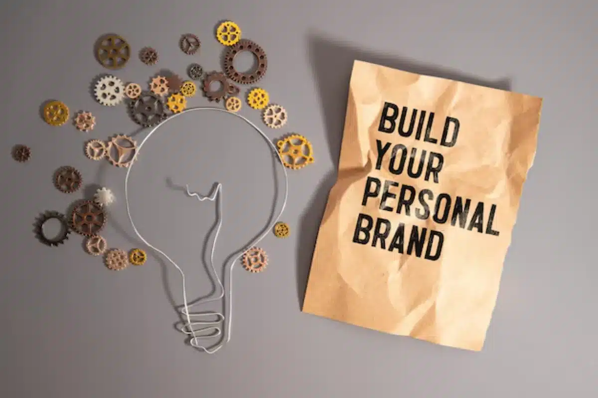 A creative display featuring a lightbulb outlined with gears and a paper bag reading Build Your Personal Brand.